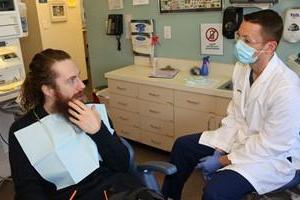 牙医与坐在椅子上的病人交谈